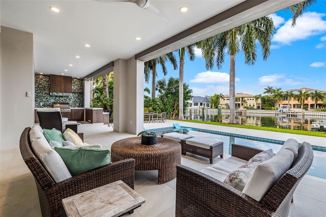 view of patio with an outdoor kitchen, an outdoor hangout area, ceiling fan, a residential view, and an outdoor pool