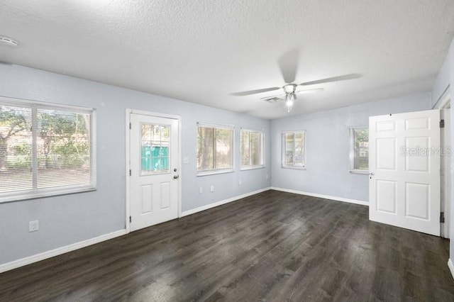 spare room featuring dark wood-type flooring, ceiling fan, and a textured ceiling