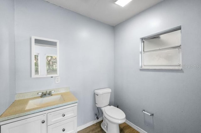 bathroom featuring toilet, hardwood / wood-style flooring, and vanity