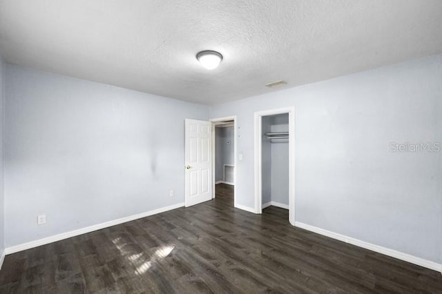 unfurnished bedroom with a closet, dark wood-type flooring, and a textured ceiling