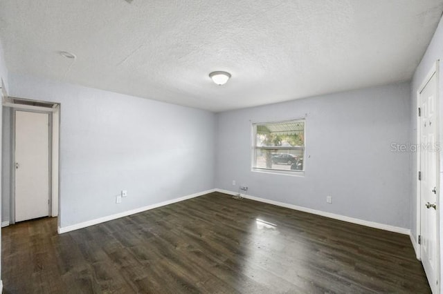 unfurnished bedroom featuring a textured ceiling and dark hardwood / wood-style flooring