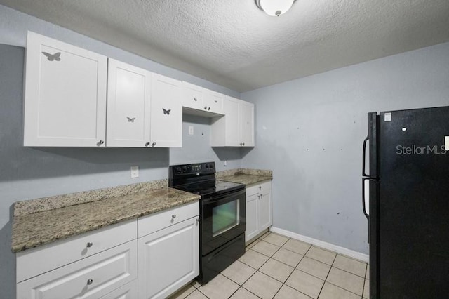 kitchen featuring white cabinetry, light tile patterned flooring, dark stone countertops, a textured ceiling, and black appliances