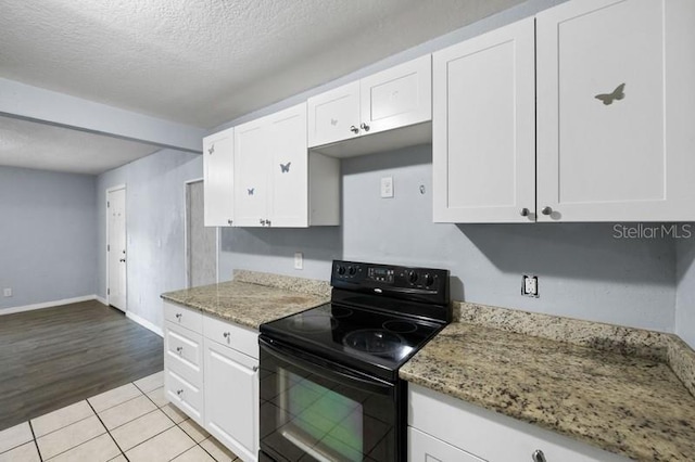 kitchen with black / electric stove, stone counters, white cabinetry, and a textured ceiling