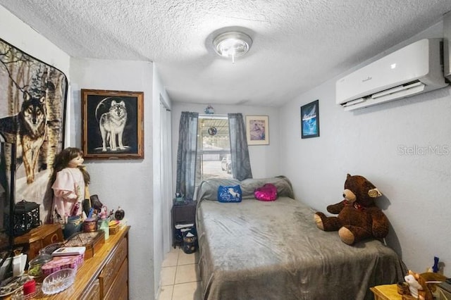 bedroom featuring a textured ceiling, light tile patterned floors, and a wall unit AC