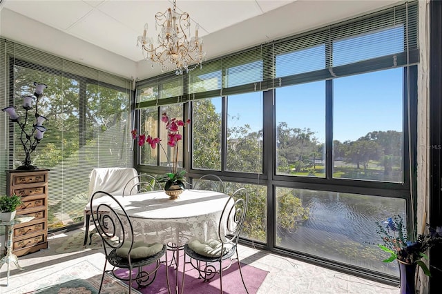 sunroom with a healthy amount of sunlight and a notable chandelier