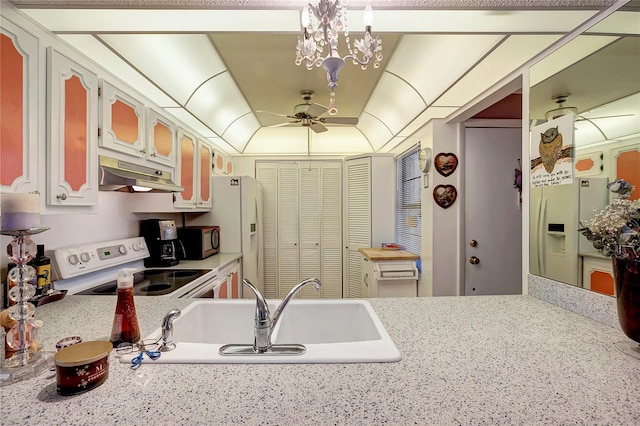 kitchen featuring stove, white cabinets, a raised ceiling, sink, and ceiling fan