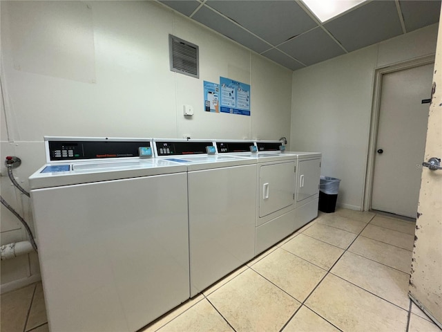 washroom with washer and clothes dryer and light tile patterned flooring