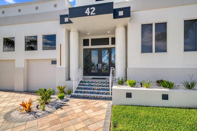 view of exterior entry with french doors and a garage