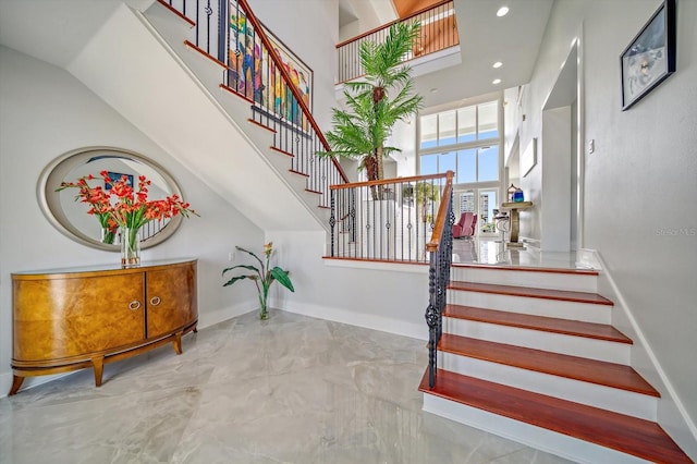 stairway featuring a towering ceiling and tile patterned flooring