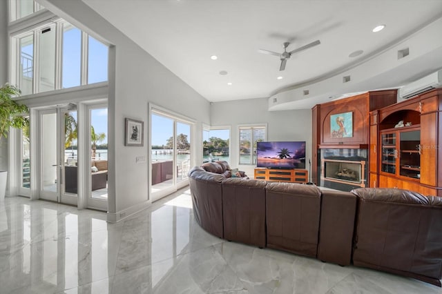 tiled living room featuring ceiling fan, french doors, a wall unit AC, and a healthy amount of sunlight