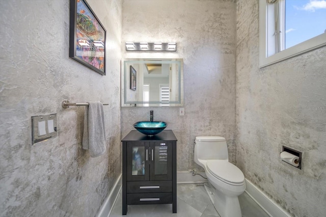 bathroom featuring toilet, tile patterned flooring, and vanity