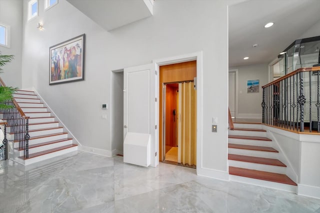 stairs with a high ceiling and tile patterned floors