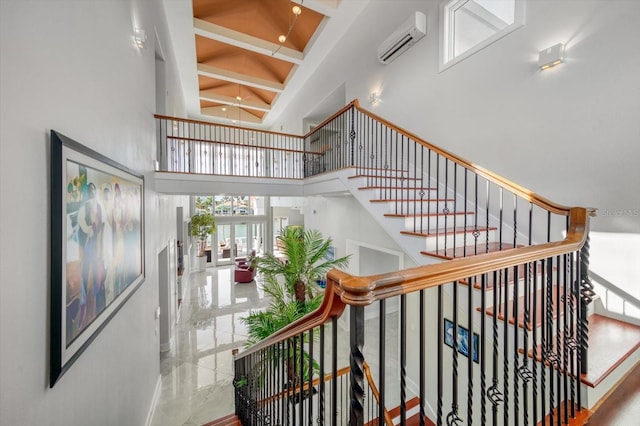 staircase featuring tile patterned flooring, a high ceiling, and a wall mounted air conditioner