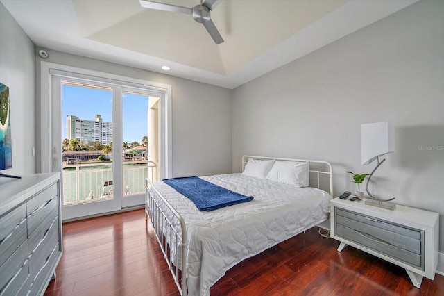 bedroom featuring ceiling fan, a tray ceiling, and hardwood / wood-style floors