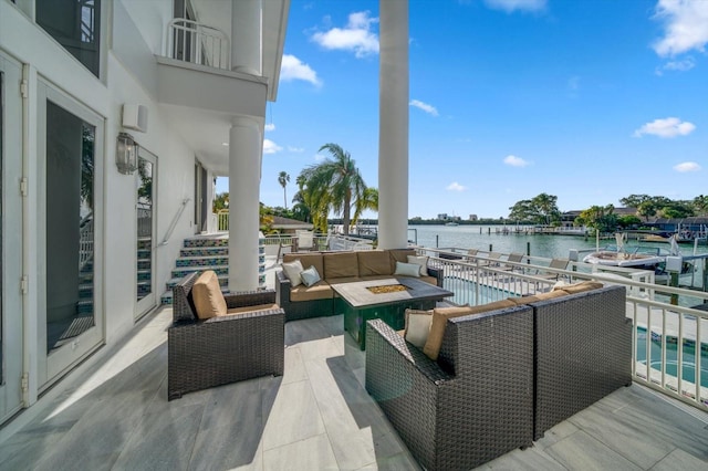 exterior space featuring an outdoor living space with a fire pit and a water view