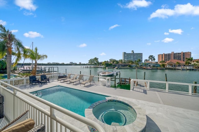 view of pool with an in ground hot tub and a water view