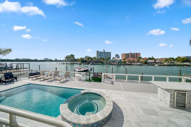 view of swimming pool with an in ground hot tub and a water view