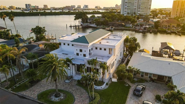 aerial view at dusk featuring a water view