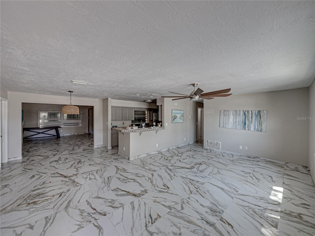 unfurnished living room featuring a textured ceiling and ceiling fan