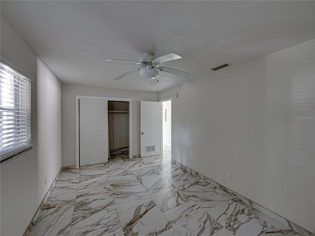 unfurnished bedroom featuring ceiling fan and a closet