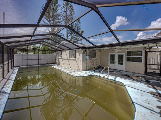 view of pool featuring french doors, glass enclosure, and ceiling fan