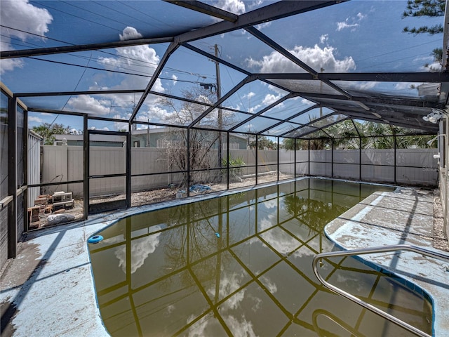 view of pool featuring glass enclosure