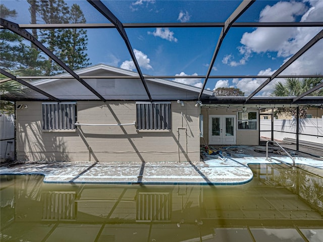 snow covered pool with french doors and a lanai