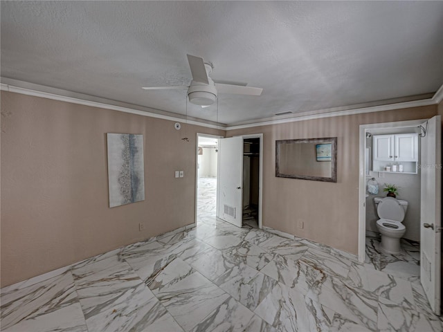 unfurnished bedroom featuring a closet, connected bathroom, ceiling fan, and crown molding