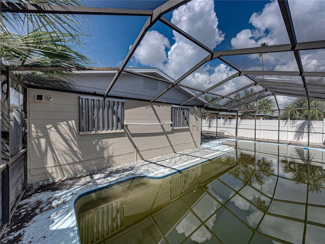 exterior space featuring glass enclosure and an empty pool