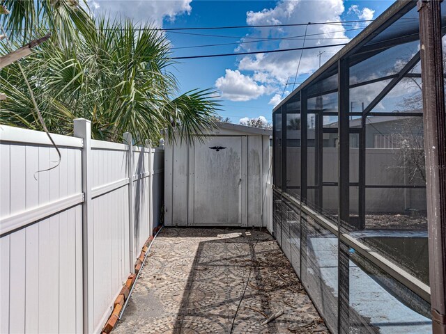 view of yard featuring glass enclosure and a storage shed