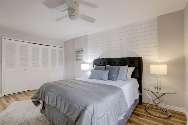 bedroom with a ceiling fan, a closet, baseboards, and wood finished floors