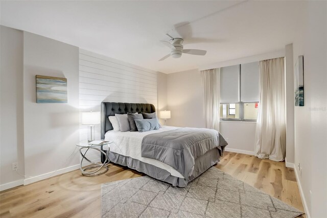 bedroom with light wood-style floors, baseboards, and a ceiling fan