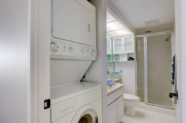 washroom with laundry area, tile patterned floors, and stacked washer / drying machine