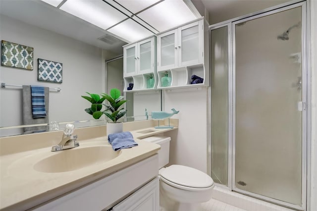 full bathroom featuring a stall shower, vanity, and toilet