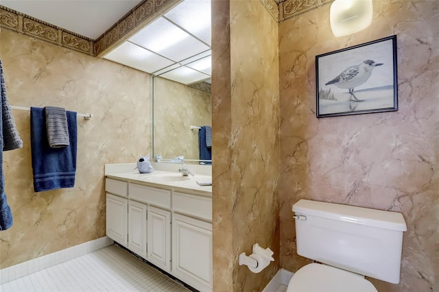 half bath with tile patterned flooring, vanity, and toilet