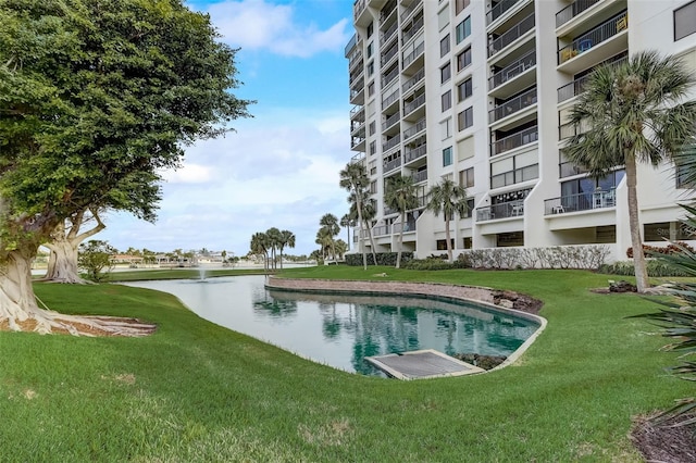 view of pool featuring a water view and a lawn