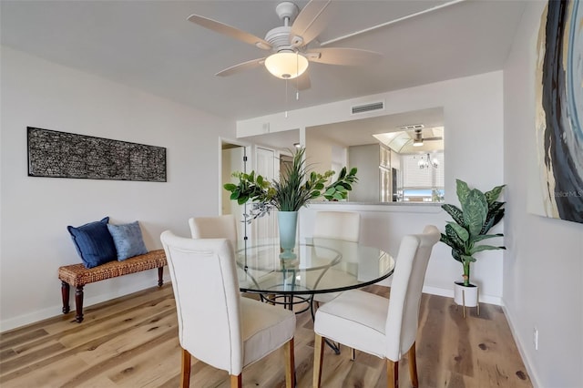 dining area featuring light wood-style flooring, visible vents, ceiling fan, and baseboards