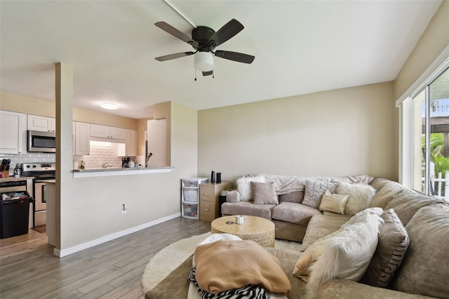 living room with ceiling fan and wood-type flooring