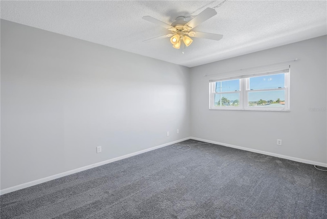 empty room featuring dark carpet, ceiling fan, and a textured ceiling