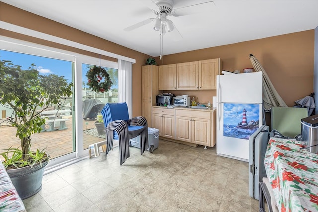 interior space featuring light brown cabinets, white fridge, ceiling fan, and light tile flooring