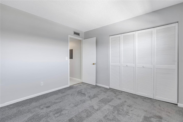 unfurnished bedroom featuring a textured ceiling, a closet, and carpet