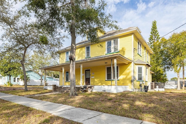 farmhouse featuring a front yard and covered porch