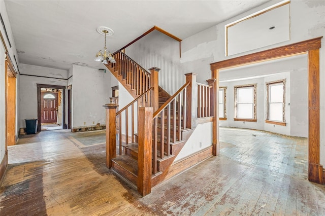 stairs with hardwood / wood-style flooring and a chandelier