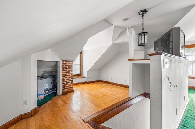 additional living space featuring lofted ceiling and wood-type flooring