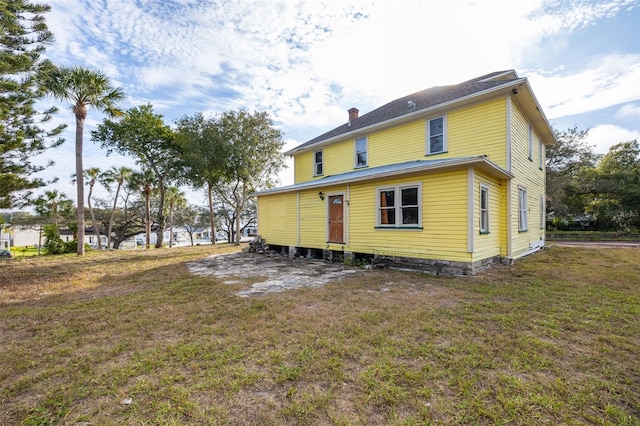 rear view of house featuring a yard