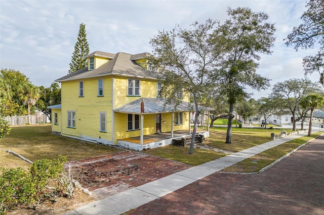 view of front of house with a front yard and covered porch