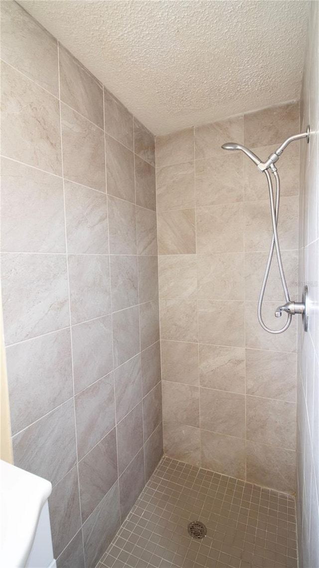 bathroom featuring tiled shower and a textured ceiling