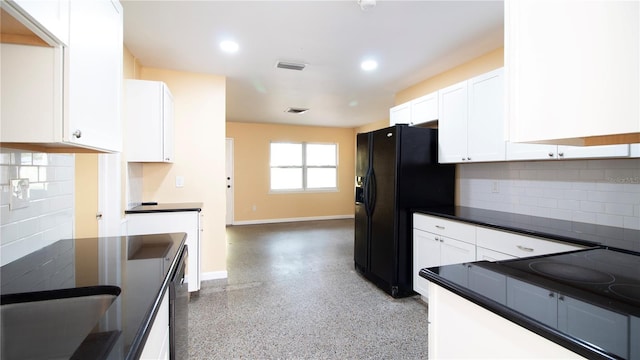 kitchen with black fridge, white cabinets, and backsplash