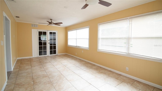 tiled spare room with crown molding, french doors, and ceiling fan