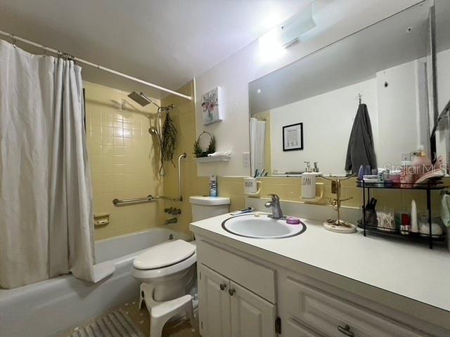 full bathroom with vanity, shower / tub combo, and toilet